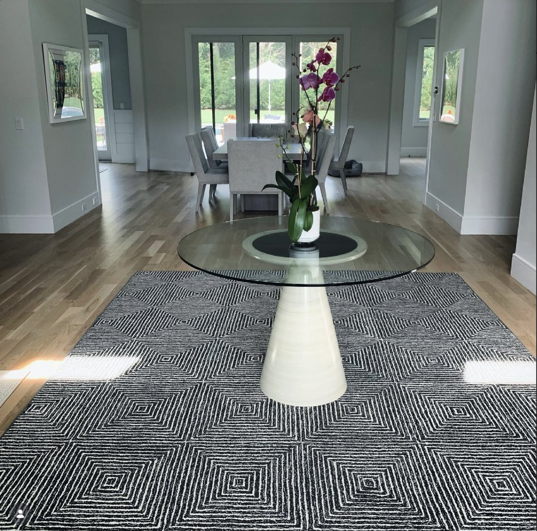 Geometric natural-fiber rug in a bright Hamptons dining room